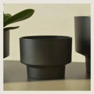 Close view of black minimalist round planter texture and pedestal base