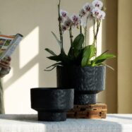 Black hammered round planters styled with orchids