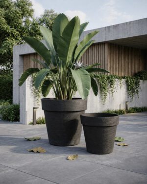 Black jumbo stone textured planters in a modern courtyard